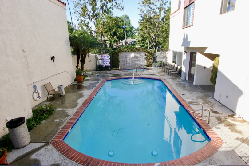 THE BACKSIDE OF THE HOUSE WITH SWIMMING POOL AND SHOWS THE LOT OF TREES PLANTS WHICH IS LOCATED IN THE CITY OF GARDEN GROVE
