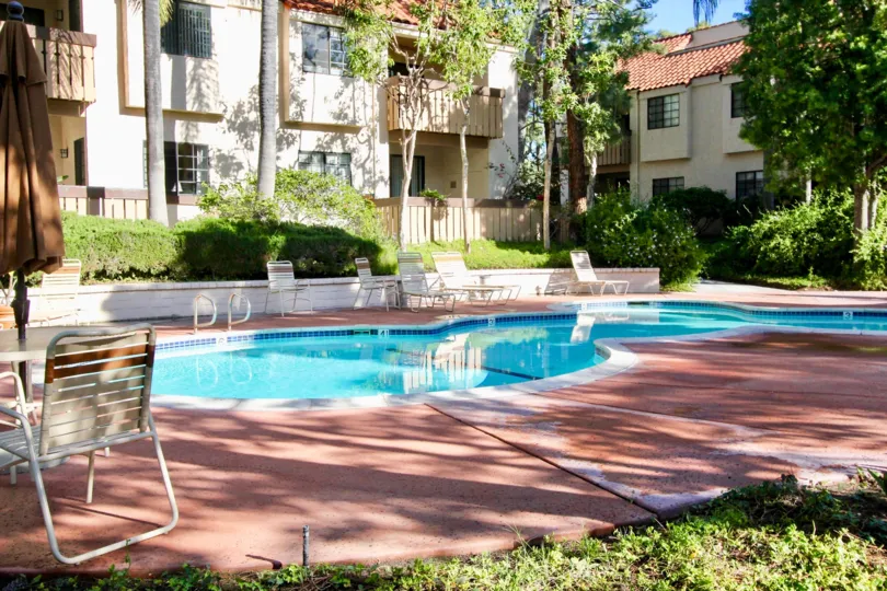 A shaded area showing a clear pool in a hotel located in the Village Green community of Garden Grove California.