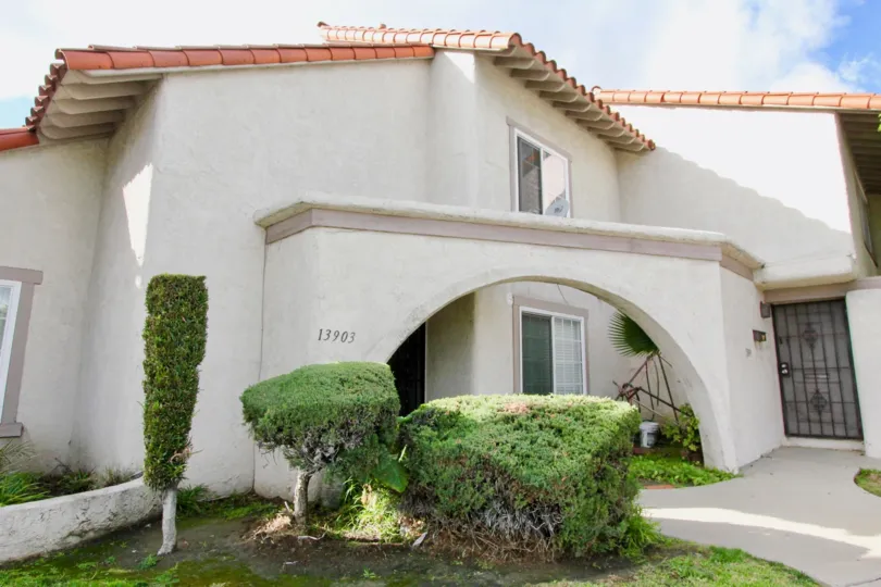 THIS IMAGE VIEWS THE FRONT OF THE HOUSE AND SHOWS THE PLANTS, DOOR NUMBER ON THE WALL THAT IS SITUATED IN THE CITY OF GARDEN GROVE