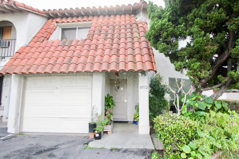 a sunny day in the wes grove with house that has numbered as 8972 and roofless top