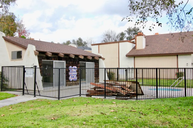 THE HOUSE IN THE YOCKEY CONDOMINIUMS WITH THE GATE, LAWN, PLANTS, TREES