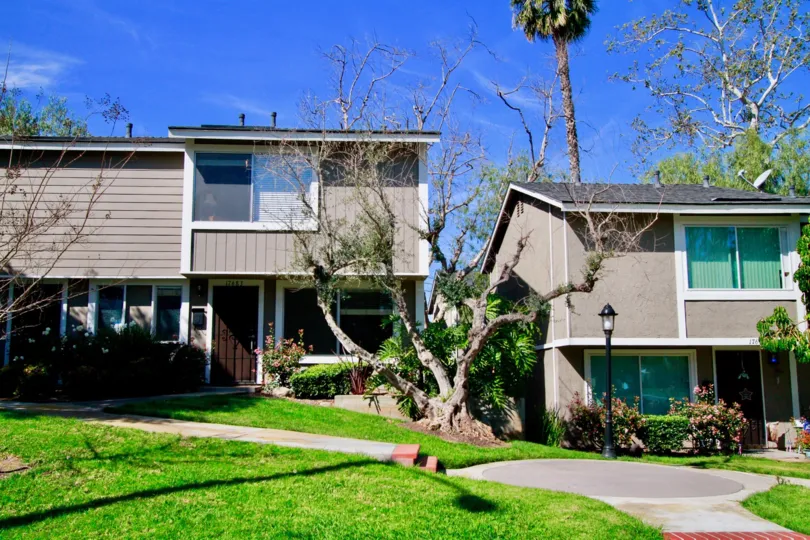 A BUNGALOW WITH GUEST HOUSE AND A GARDEN ALSO NEAR TO THE HOUSE A ROAD THAT GOES TO THE TWO PLACES AND SOME TREES AND LAMP STAND ALSO AVAILABLE.