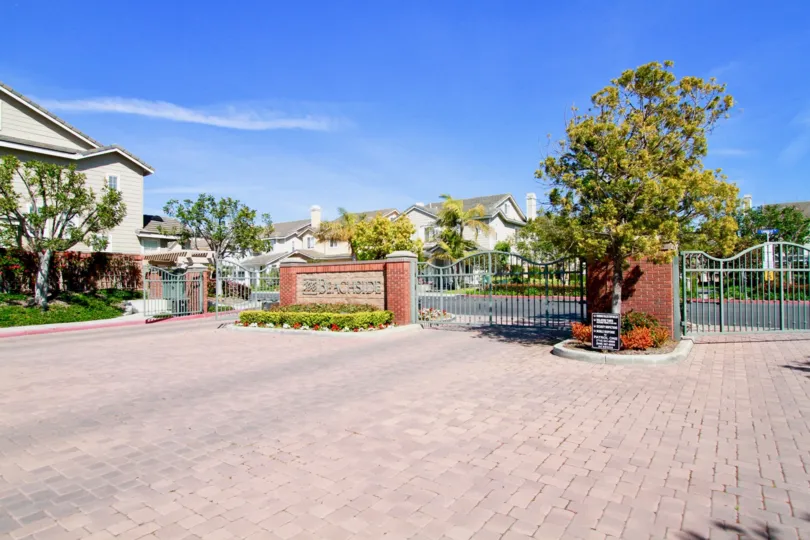 Beachside entrance with a side and metal gate on a sunny day.