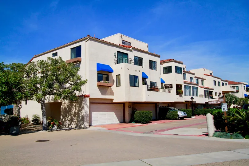 Broadmoor Huntington Harbor Huntington Beach California building light rose color paint front glass window balcony attached big tree front side