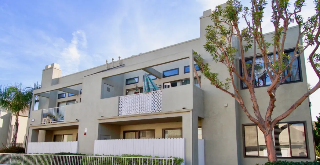 a tree which is stand in front of a long home in brookstone of huntington beach in california