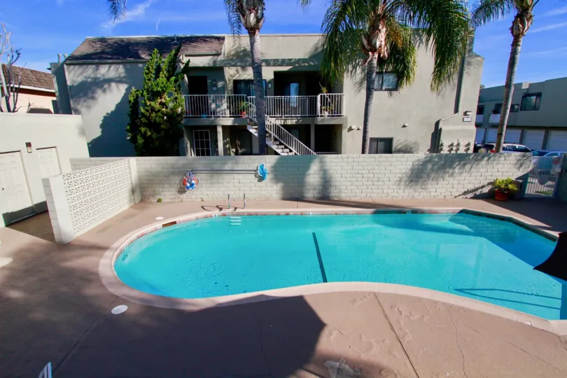 Villas having staircase near swimming pool with palm trees in Brookstone of Huntington Beach