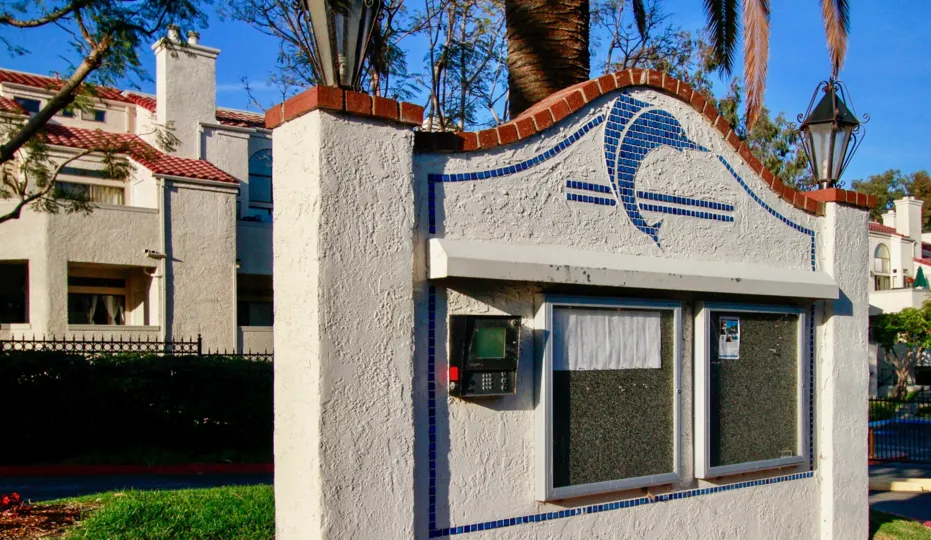 The keypad entrance to the Cabo Del Mar community. There is a tile dolphin on the keypad entrance.