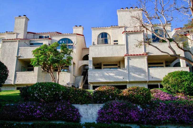 Cabo Del Mar apartments with balconies and staircases on a sunny day.
