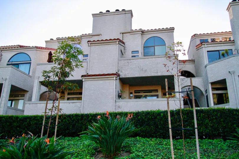 THE BUILDING WITH BLUE GLASS WINDOWS AND SMALL GARDEN IN FRONT OF THE HOUSE AND A CUTE BALCONY AT THE GROUND FLOOR AVAILABLE AT THE MORNING TIME