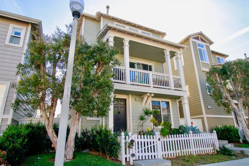 A HOUSE WITH ENTRANCE AND CLOSED DOOR AND A SMALL BALCONY AT THE FIRST FLOOR AND A LAMP AT THE OUTSIDE OF THE HOUSE AT THE MORNING TIME