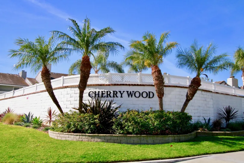Cherrywood Village stone fence with a sign on a sunny day.
