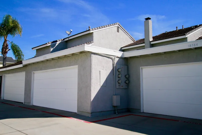 Cherrywood Village apartments with a garage and a palm tree on a sunny day.
