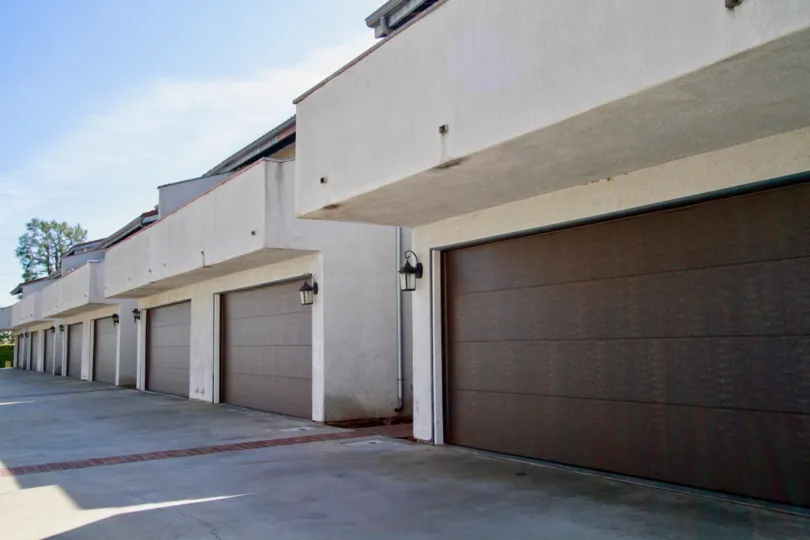 Crestview Estates apartment with a garage and lamp on a sunny day.