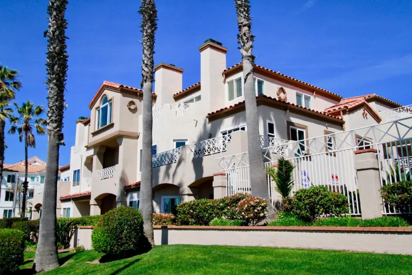Faire Rivage buildings with a fence and balconies on a sunny day.