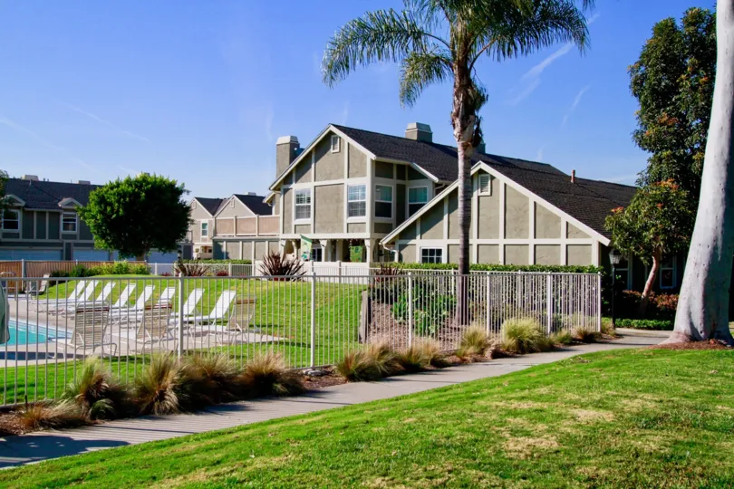 Gables apartments with a fence and a pool on a sunny day.