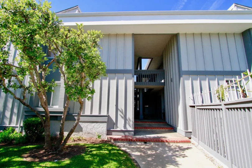 Harboring Villas apartments with a staircase and fences on a sunny day.