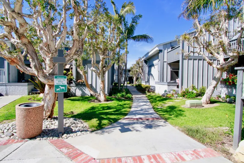 Harboring Villas sidewalk with apartments and trees on either side.