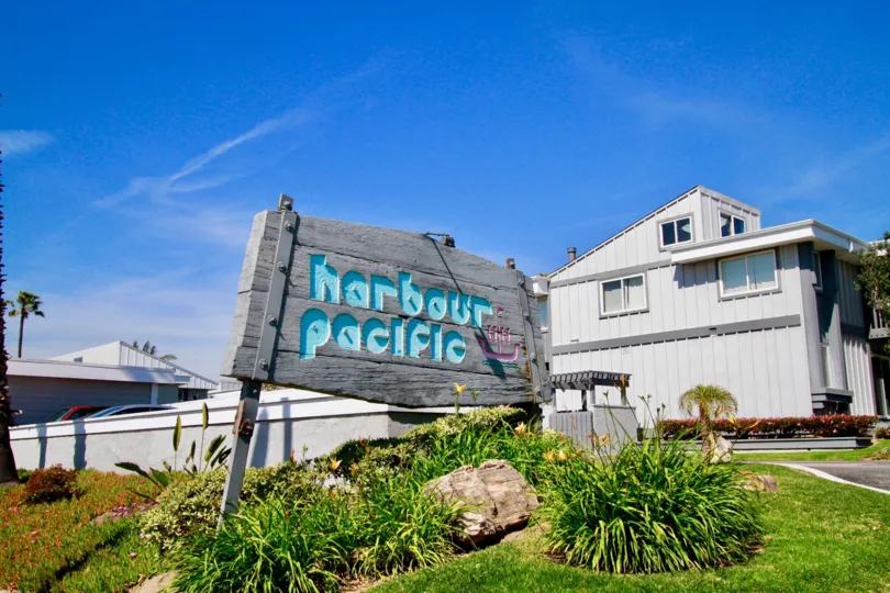 The front entrance and garden on a sunny day at the Harbour Pacific community in Huntington Beach, California.