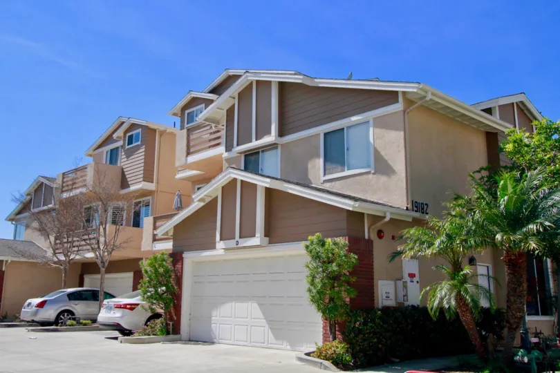 Holly Street Townhomes Huntington Beach California house red color paint leafless tree front
