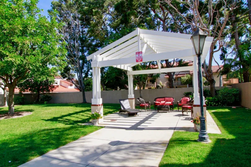 on a sunny day a white pavilion stands before the surrounding green grass