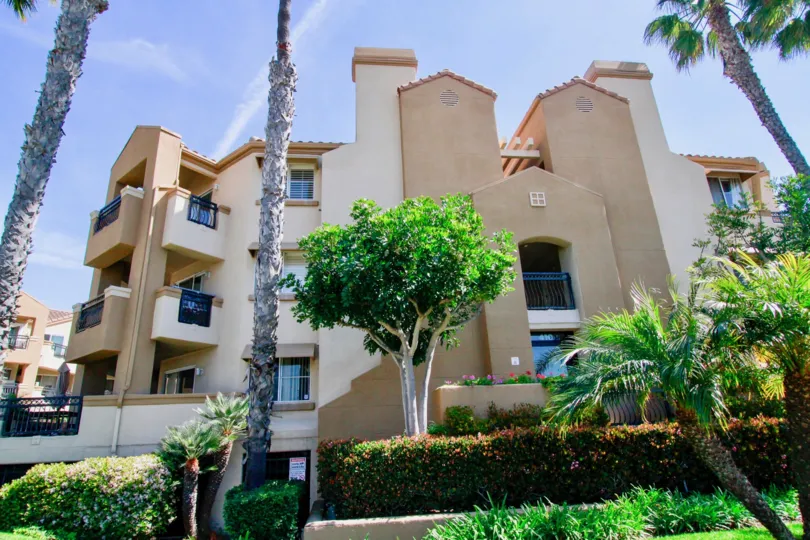 THE BUILDING LOOKS LIKE A BIG BUNGALOW AND MORE TREES AND PLANTS IN FRONT OF THE BUILDING IT HAS THREE FLOORS AND BALCONY.