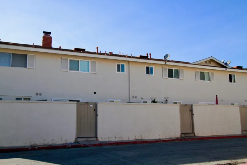 Huntington Continental apartment building with a fence and beige door.
