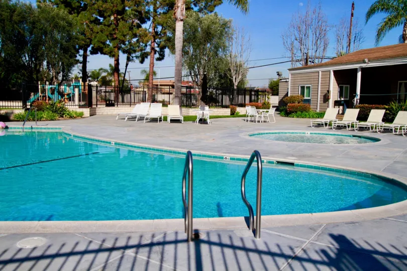THE HOUSES OR RESTAURANT WITH SWIMMING POOL WITH SITTING CHAIRS AVAILABLE A SMALL POOL ALSO NEAR TO THE ADULT POOL AT SOME TREES SURROUNDING THE PLACE.