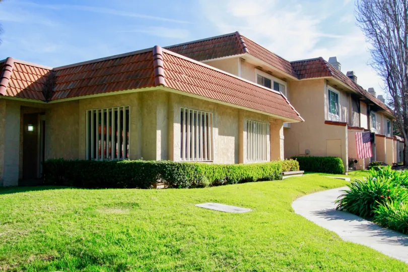 Huntington Creek apartments with windows and a sidewalk on a sunny day.