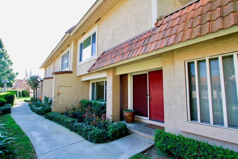 Huntington Creek sidewalk with bushes and red doors.