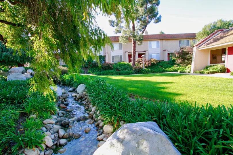 Excellent greenary with lawn and water pond in front of villas in Huntington Creek of Huntington Beach, CA