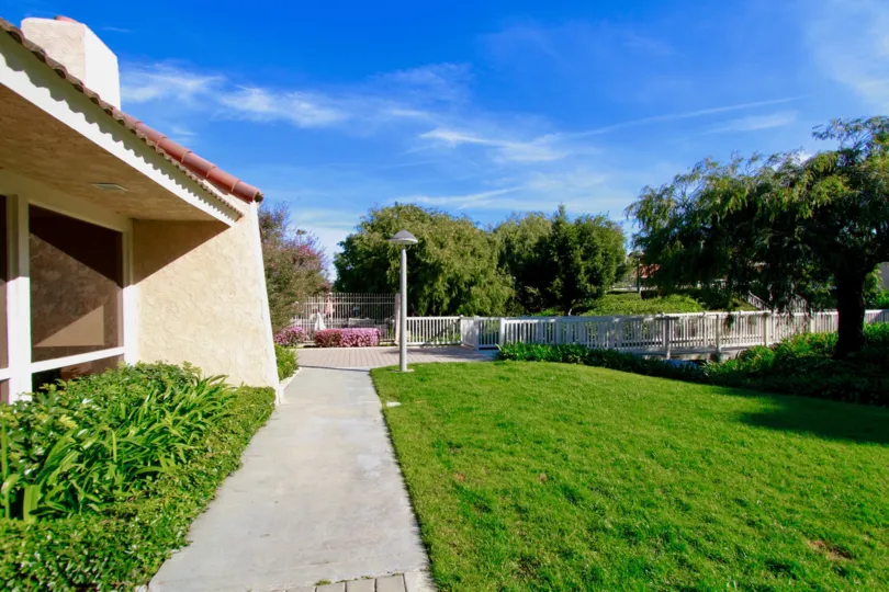 Awesome view of green lawn beside a villa with trees and bluesky in Huntington Creek of Huntington Beach