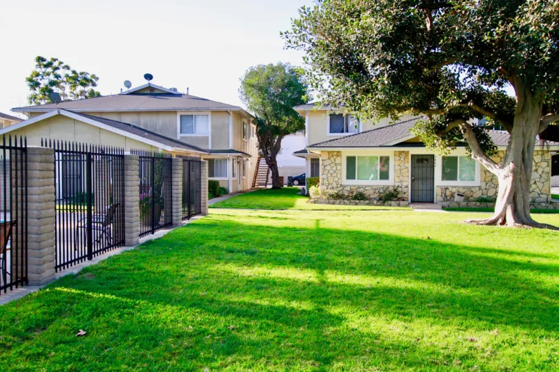 Fabulous greenish view of a lawn in front of villa with trees in Huntington Gardens of Huntington Beach