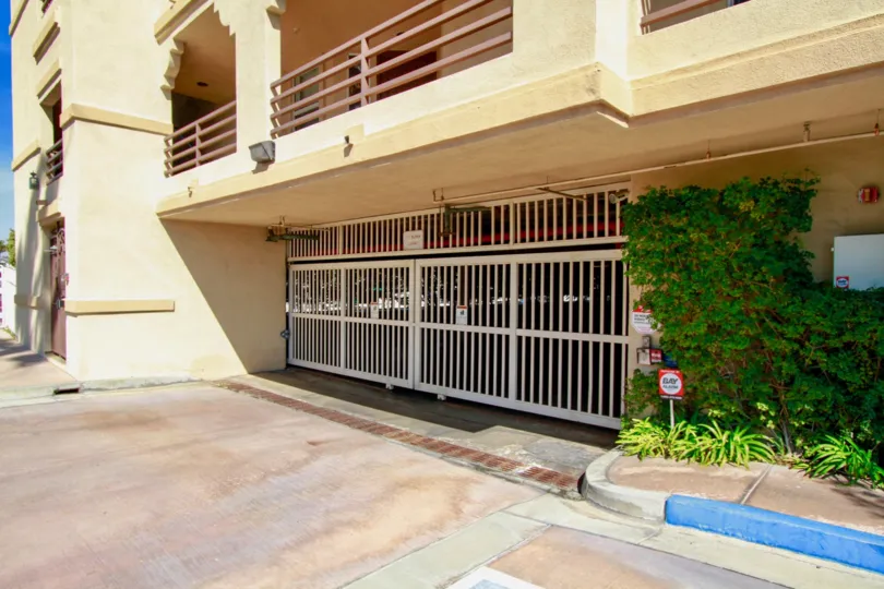 Huntington Harbour Bay Club parking garage gate with plants on a sunny day.
