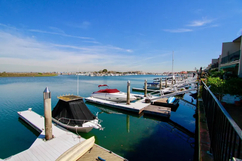 Boats of the Huntington Marina with docks and a fence on a sunny day.