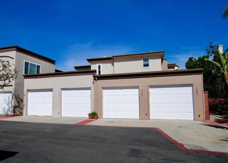 Huntington Marina apartments with garages and trees on a sunny day.