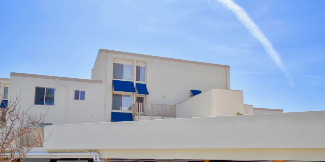 Huntington Pacific building with a fence and balcony on a sunny day.