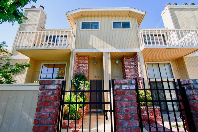 A red brick and iron gate entrance to the Huntington Terrace community townhomes.