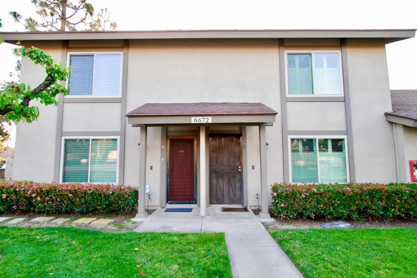 Nice stylish lawn with trees with entrance door of villa in Huntington Township of Huntington Beach