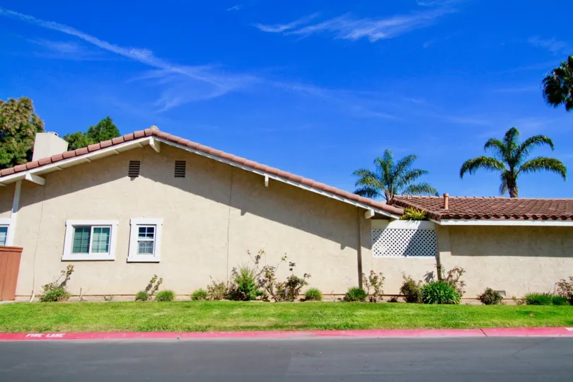 Huntington Viewpoint home with palm trees and bushes on a sunny day.