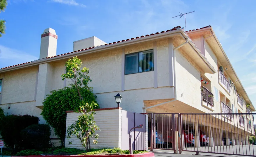 Fabulous view of villa with entrance gate and trees beside in Huntington West of Huntington Beach