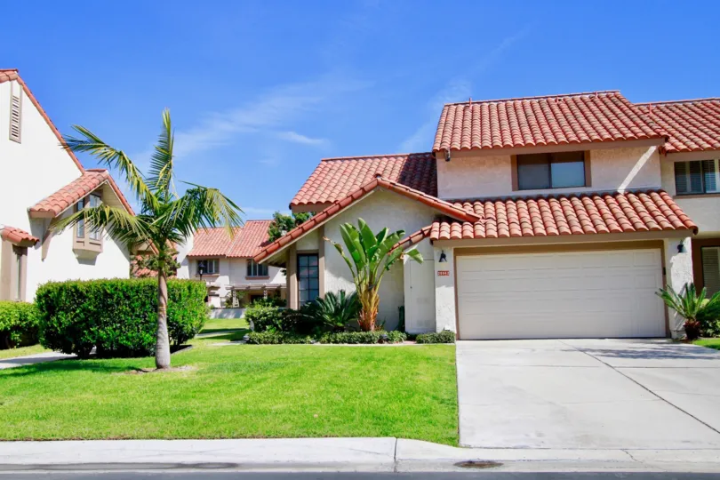 La Cuesta By the Sea home with a garage and palm trees on a sunny day.