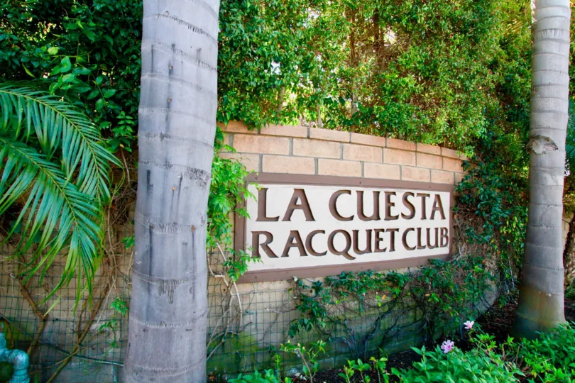 Beautiful Sign board surrounded with garden and palm trees in La Cuesta Racquet Club