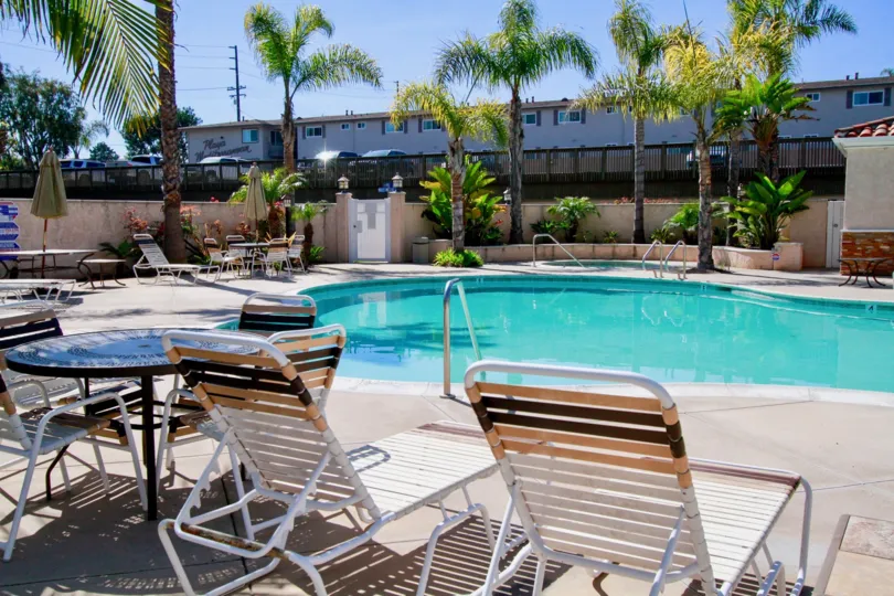 Las Brisas pool with deck chairs and tables on a sunny day.