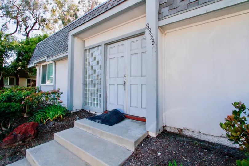Mariners Cove West building with a sidewalk and plants on either side.