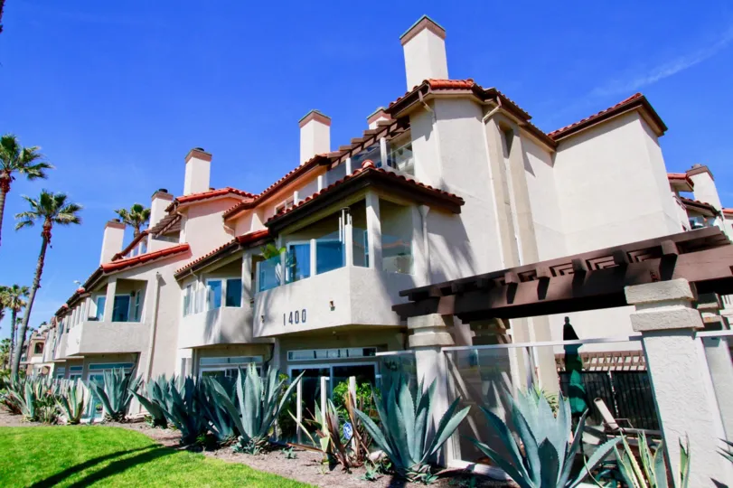 Nice view of villas with balconies and lawn in front in Ocean Breeze of Huntington Beach