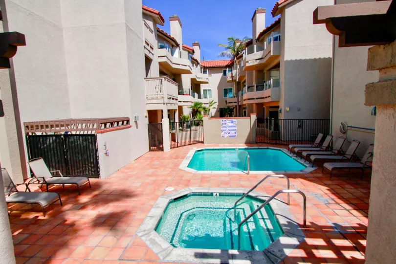 The houses in the Ocean Breeze is like a resort in the middle of the houses with swimming pool, chair and trees.