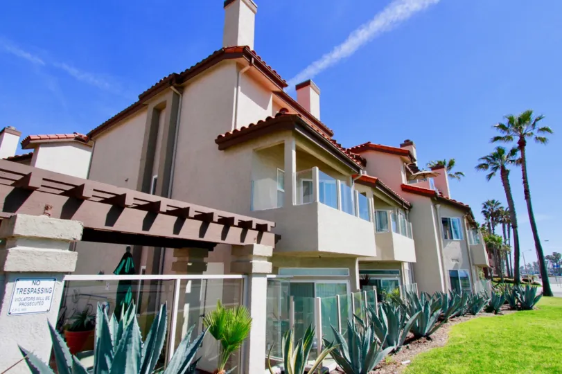 A sunny day the big buildings with glass windows in the Ocean Breeze with cactus plants and green grass.
