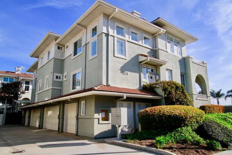 Pacific Park Villas apartment building with bushes and other plants in front.