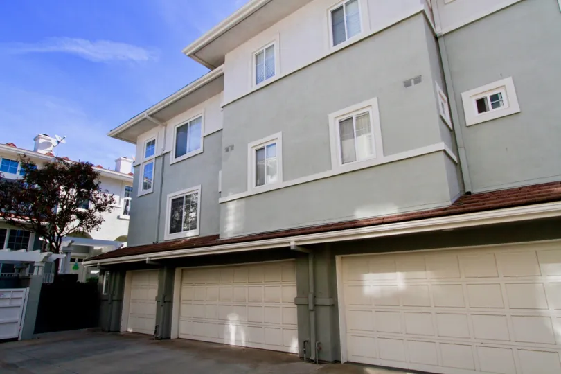 Pacific Park Villas three story buiilding with three garages on a sunny day.