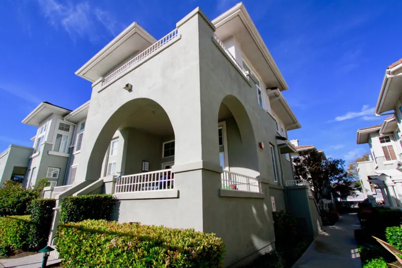 Pacific Park Villas building with a sidewalk and bushes next to it.